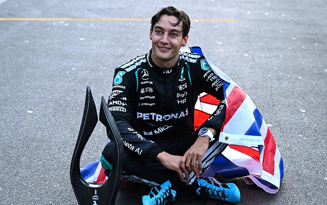 George Russell sitting on the grid with his winner’s trophy and a Union flag